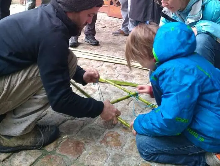 Animateur montrant le travail du bambou à un enfant