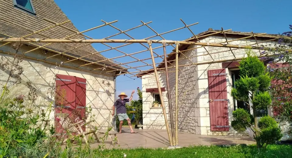 Pergola en bambou adossée à une maison en pierre