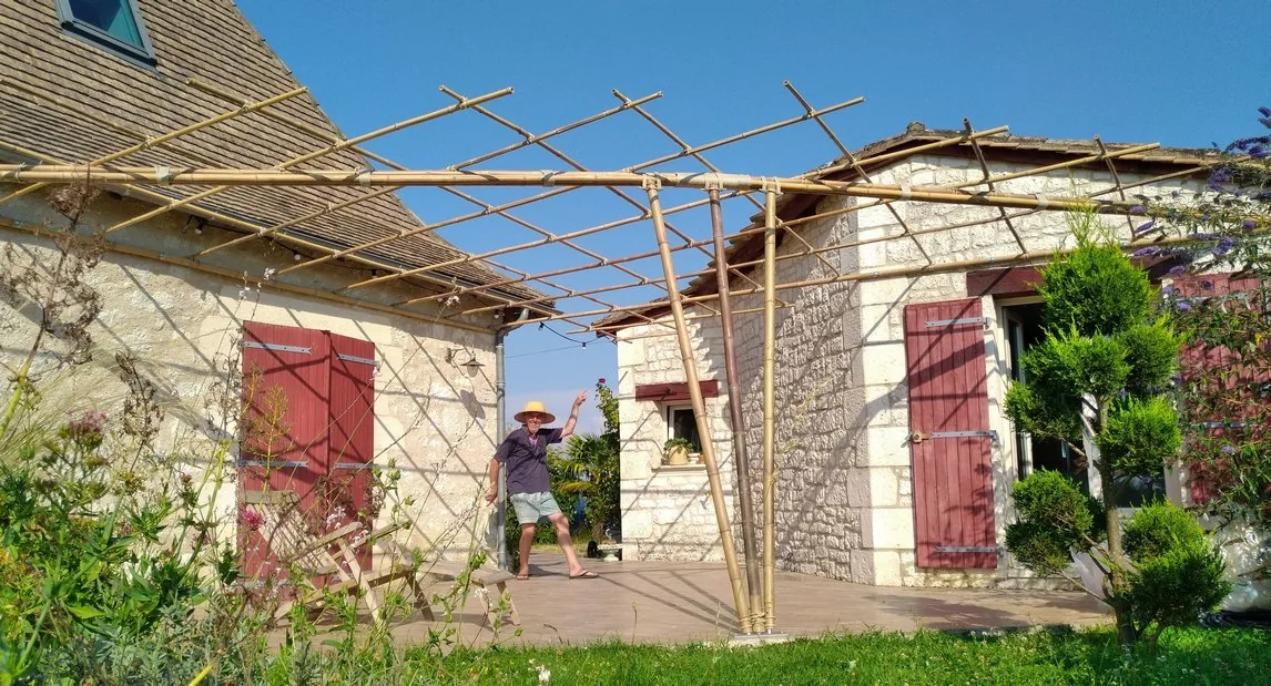 Pergola en bambou adossée à une maison en pierre